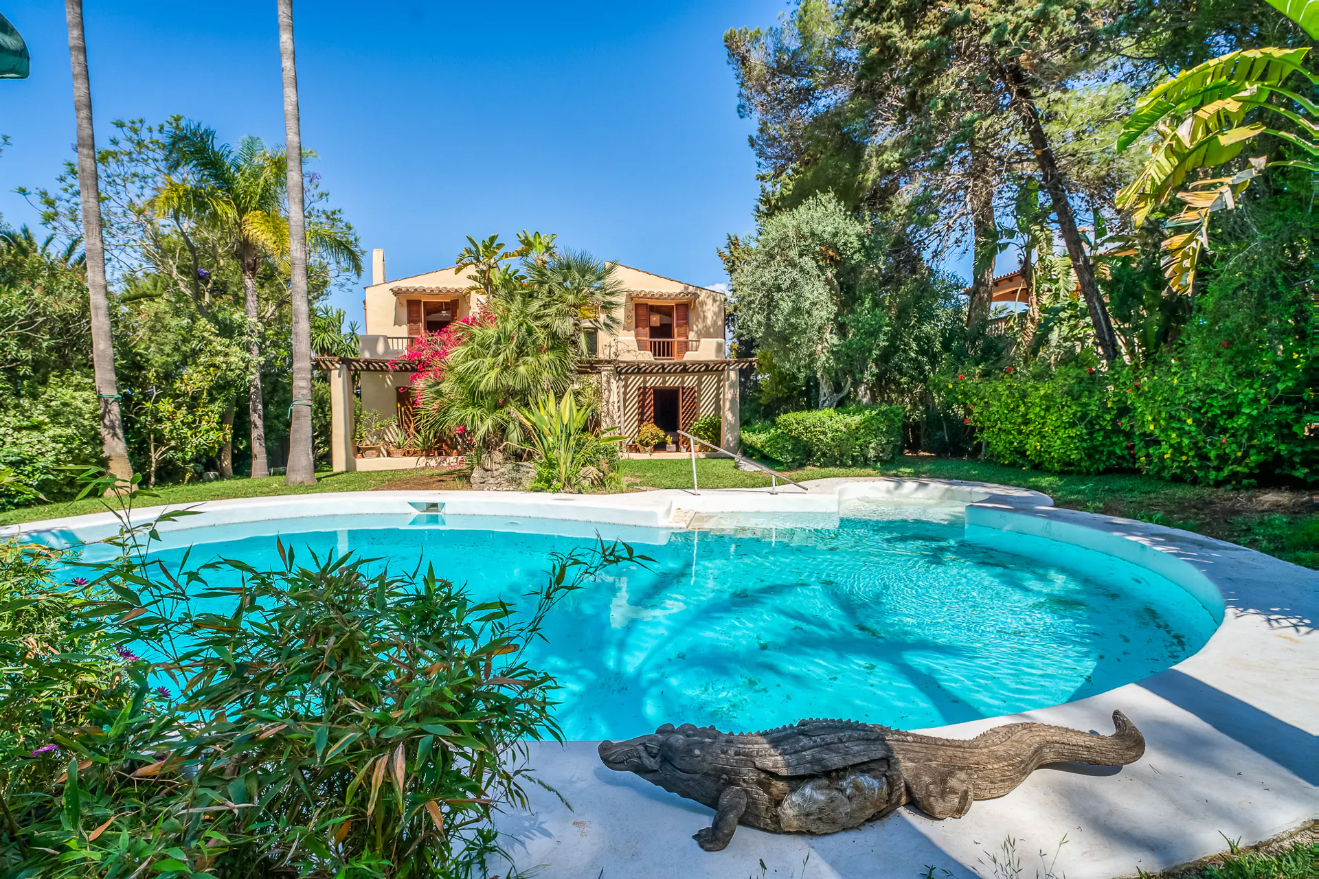 Swimmingpool mit Villa im Hintergrund