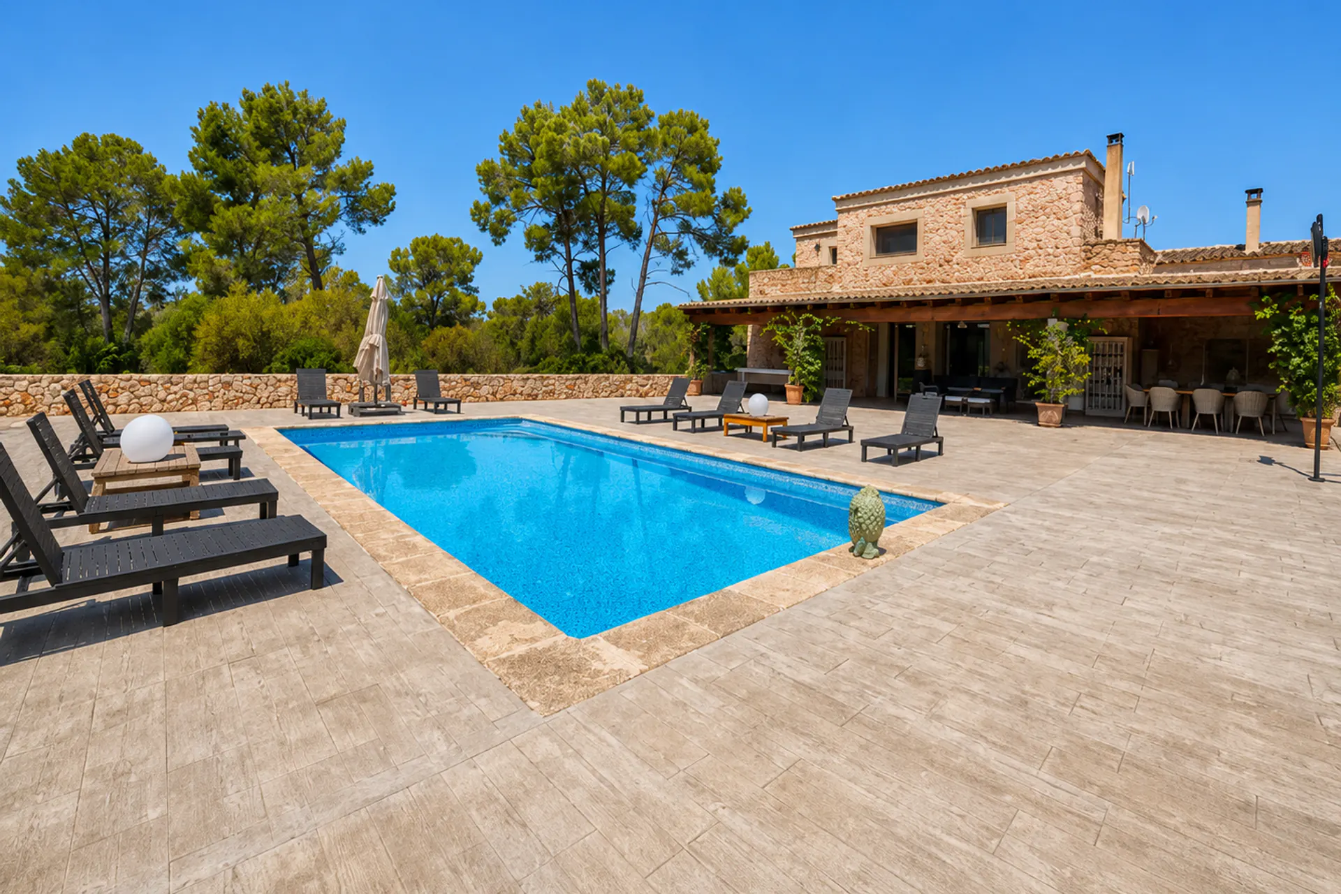 Piscina davant d'una casa de camp tradicional de pedra